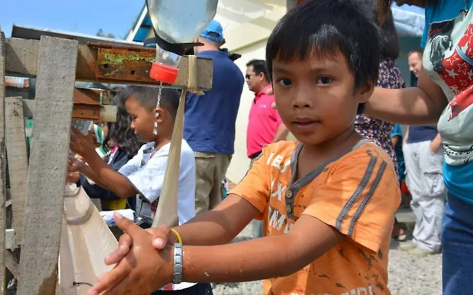 A boy in Tacloban is washing his hands. | United Internet for UNICEF A boy in Tacloban is washing his hands.