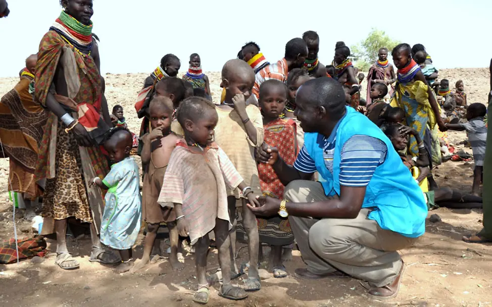UNICEF-Mitarbeiter Philip Aemun mit Kindern im Dorf Ekengot | © UNICEFKenya/Oloo Dürre in Kenia: Philip Aemun mit Kindern des Turkana-Stamms im Dorf Ekengot