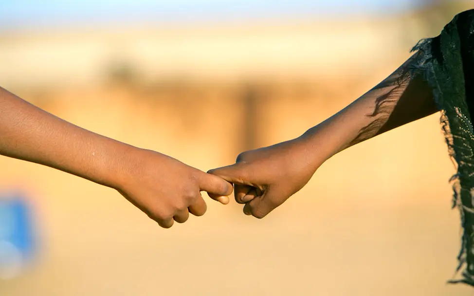 Gemeinsam stark. | © UNICEF/Pirozzi Zwei Kinderhände greifen ineinander und halten sich fest.