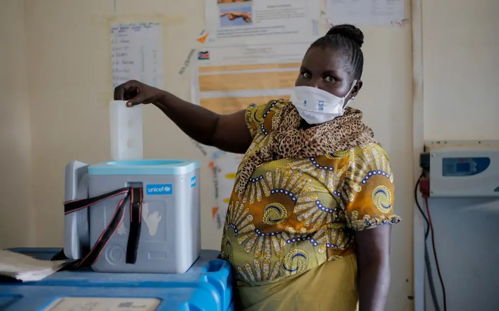 Südsudan: Kühlketten als Voraussetzung wirksamer Impfungen | © UNICEF/Obel Eine medizinische Mitarbeiterin aus dem Südsudan entnimmt Impfstoffe aus einer Kühlbox.