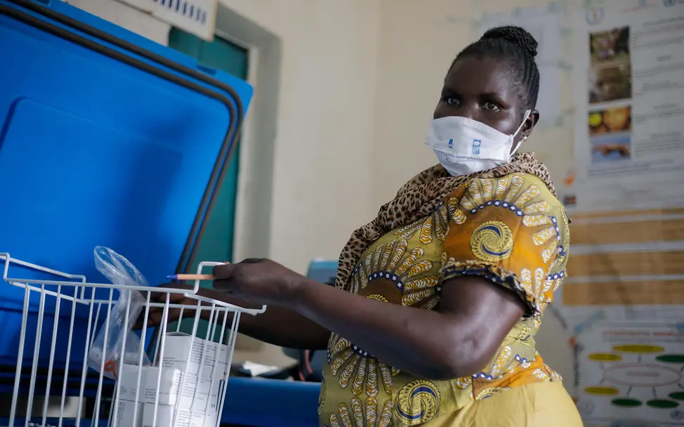 COVAX-Impfkampagne: Eine Gesundheitshelferin holt Impfstoffe aus einem Kühlschrank | © UNICEF/Obel Corona-Impfungen: UNICEF stellt Kühlschränke für die Lagerung der Impfstoffe bereit. Jetzt spenden!