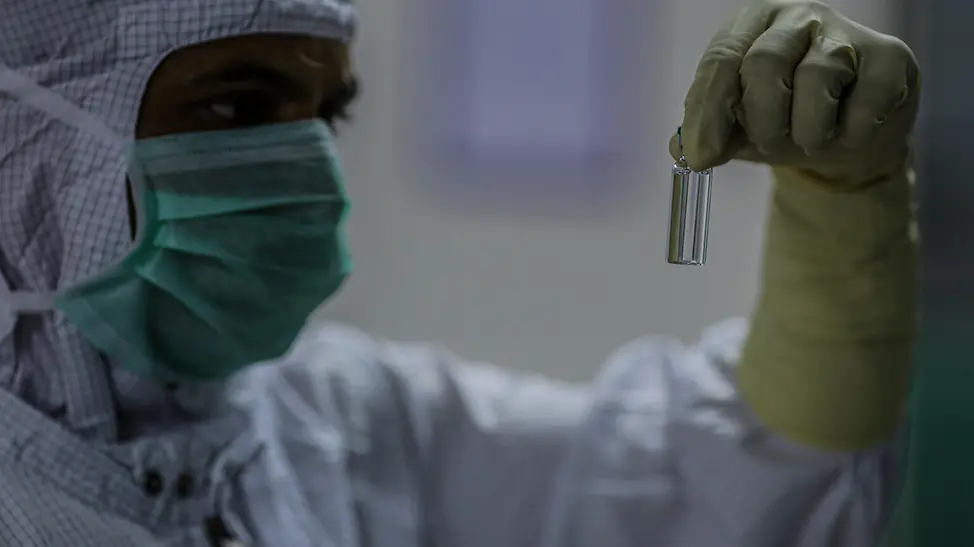 UNICEF: Ein Arbeiter überprüft eine Corona-Impfdose. | © UNICEF/COVAX/Dhiraj Singh UNICEF: Ein Arbeiter überprüft eine Corona-Impfdosis.