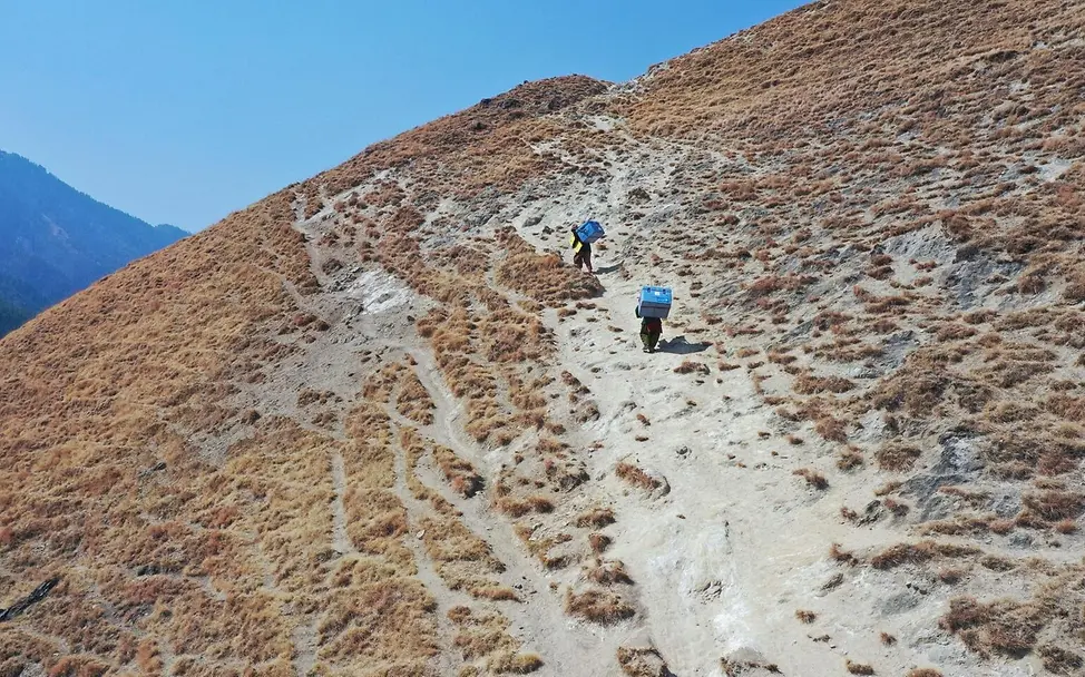 Nepal: Helfer tragen Corona-Impfstoffe durchs Gebirge. | © UNICEF Nepal: Helfer tragen Corona-Impfstoffe durchs Gebirbe.