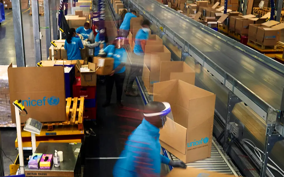 Arbeiten am Fließband: Notfallsets verpacken im Akkord. | © UNICEF/Mansour Hilfsgüter: UNICEF-Notfallsets werden am Fließband verpackt.