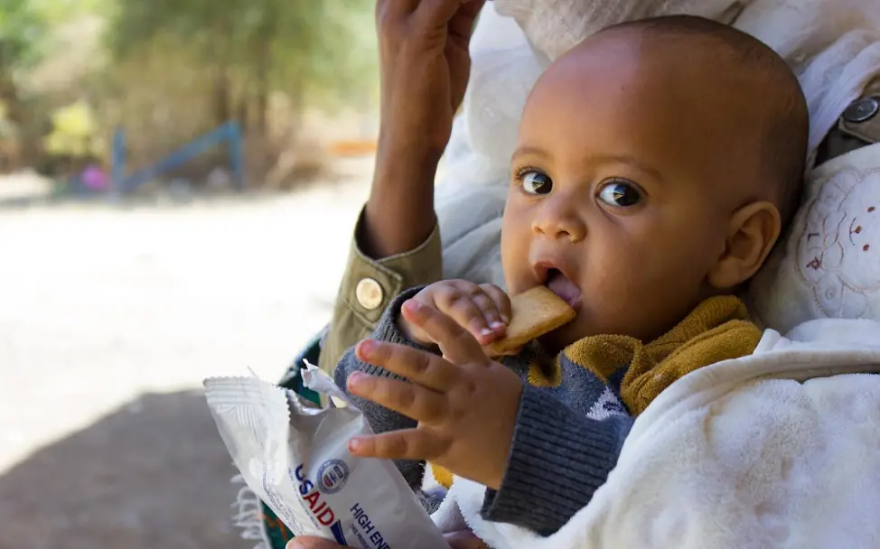Die drohende Hungersnot in Äthiopien gefährdet Kinder in der Region Tigray. | © UNICEF/Leul Kinfu Hunger in Äthiopien: Ein Baby beißt in einen nährstoffhaltigen Keks.