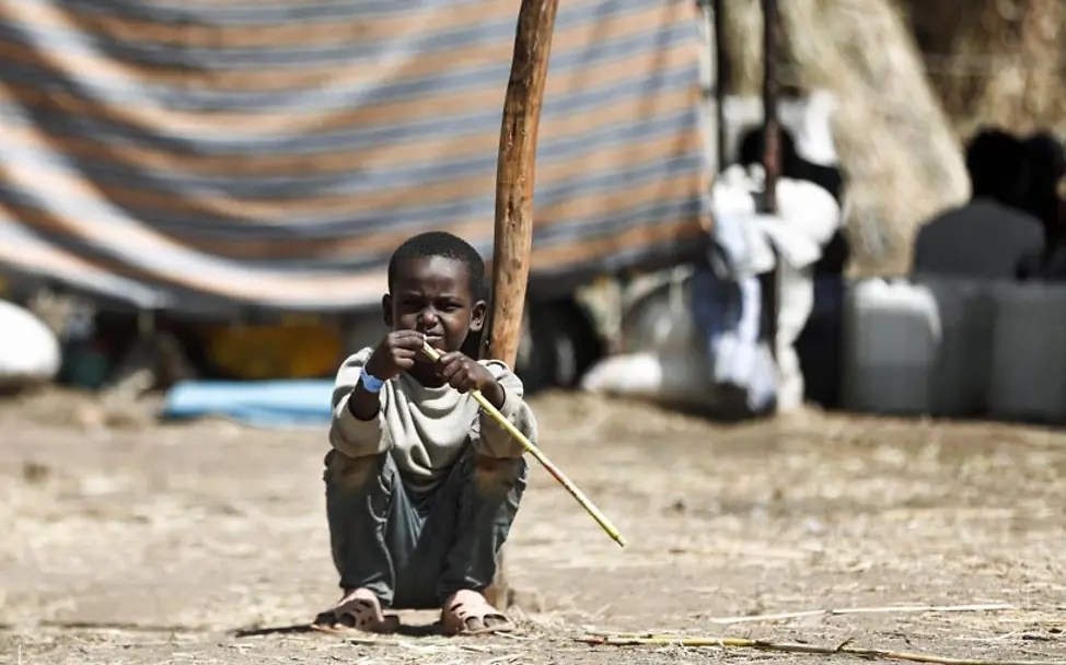 Durch den Bürgerkrieg in Äthiopien sind Tausende Menschen geflüchtet. | © UNICEF/Abdalkarim Katastrophe für Flüchtlinge: Ein äthiopischer Junge sitzt vor einer Zeltunterkunft in einem Flüchtlingscamp.