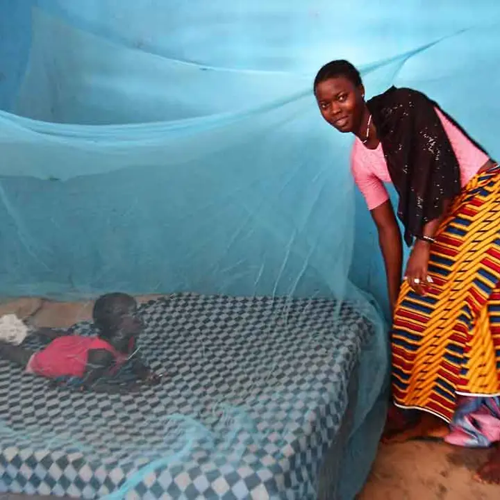 Elfenbeinküste: Eine Mutter schützt ihre zweijährige Tochter mit einem Moskitonetz © UNICEF/Dejongh