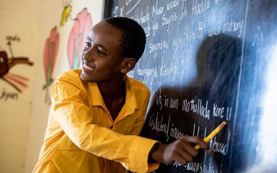 Investitionen in Bildung im Bereich Klima-/Umweltschutz | © UNICEF/Taxta Junge zeigt mit Stift auf Schultafel