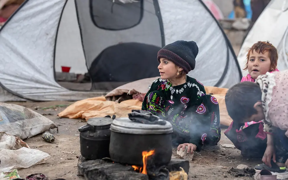 Winter in Afghanistan: Kinder sitzen in einem Flüchtlingscamp um eine Feuerstelle | © UNICEF/Bidel Afghanistan Kinder: Kinder sitzen in einem Flüchtlingscamp um eine Feuerstelle