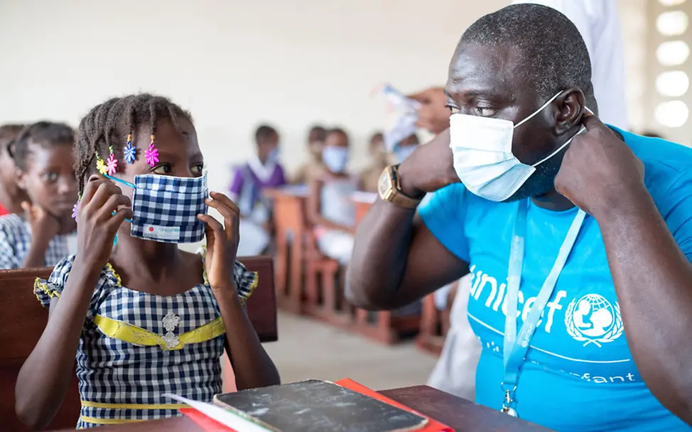 Corona in Afrika: Schülerinnen in der Elfenbeinküste ziehen eine Maske auf | © UNICEF/Diarassouba Corona in Afrika: Schülerinnen in der Elfenbeinküste ziehen eine Maske auf