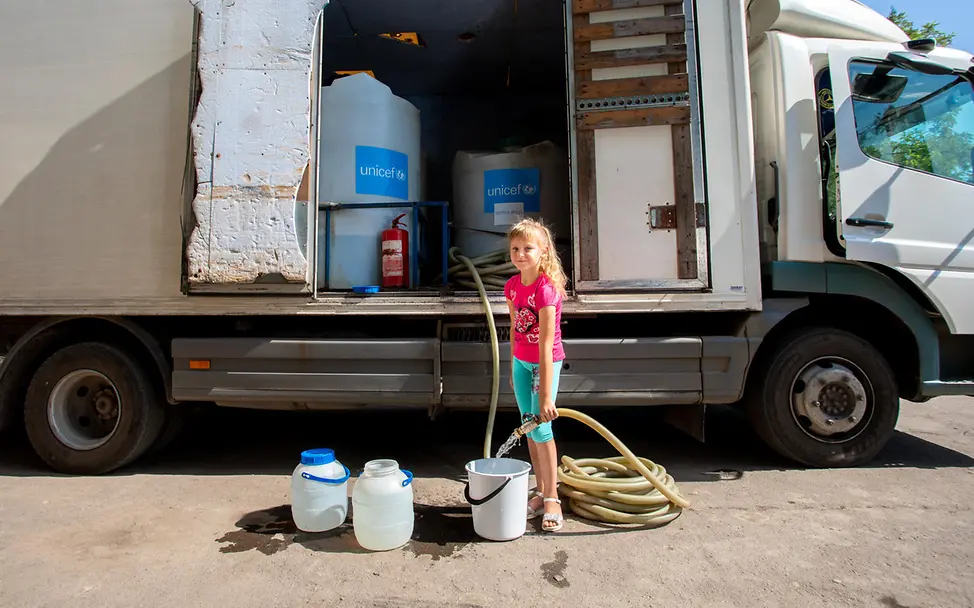 Die achtjährige Dasha füllt Eimer mit sauberem Wasser, das von UNICEF bereitgestellt wurde.| © UNICEF/Filippov ukraine Die achtjährige Dasha aus Pavlopil füllt Eimer mit sauberem Wasser, das von UNICEF bereitgestellt wurde.