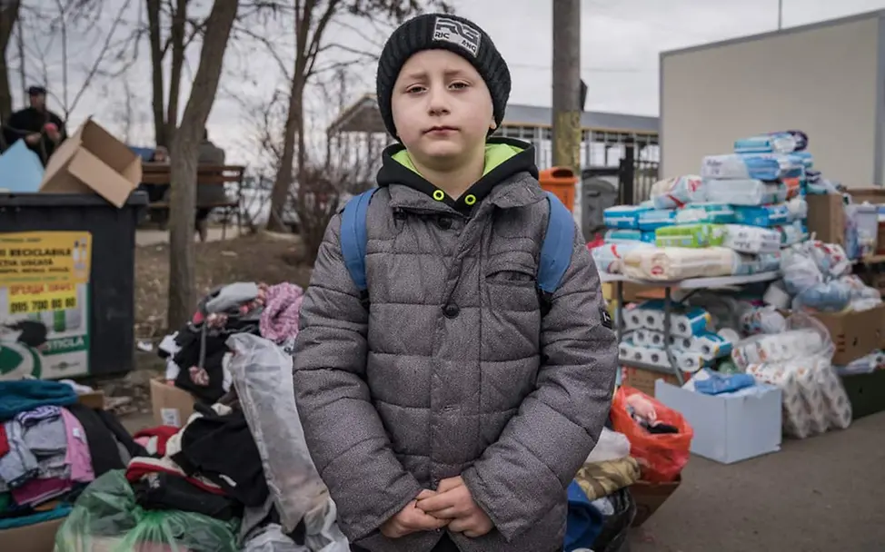Ukraine-Konflikt: UNICEF setzt sich für unbegleitete minderjährige Flüchtlinge ein. | © UNICEF/Moldovan Ukraine Flüchtlinge Kinder: Hinter dem Grenzübergang nach Rumänien stapeln sich Hilfsgüter und Gepäckstücke.