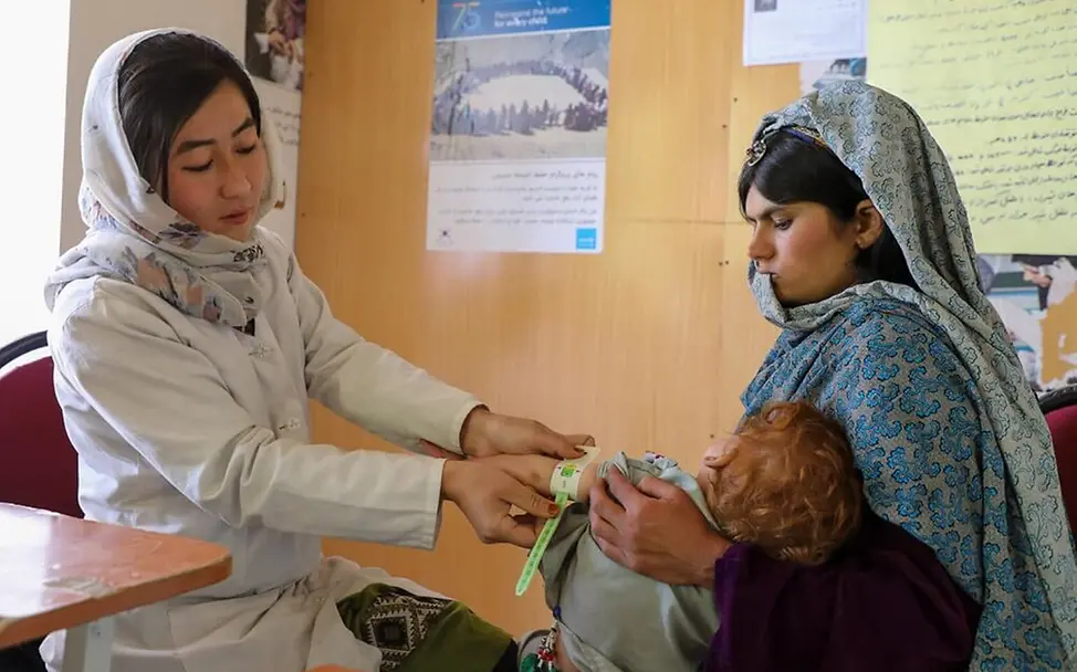 Eine afghanische Ernährungshelferin untersucht ein Kind auf Mangelernährung. | © UNICEF/Fazel Hunger in der Welt: Eine Ernährungshelferin in Afghanistan untersucht ein Kind und setzt sich so gegen den Welthunger ein.