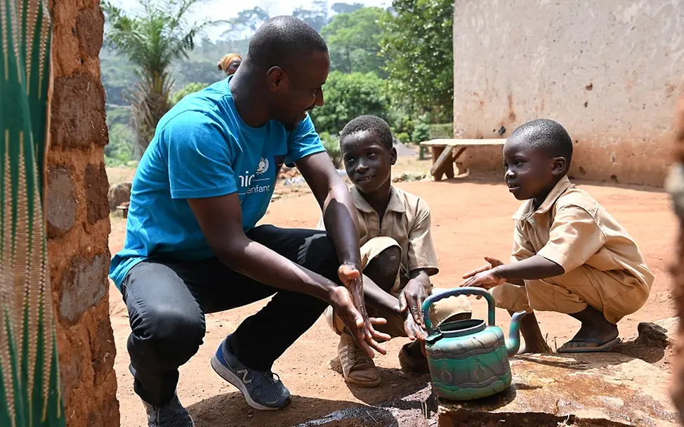 Guy Pacome, WASH-Spezialist von UNICEF, zeigt Kindern in Côte d’Ivoire, wie sie sich die Hände waschen können.