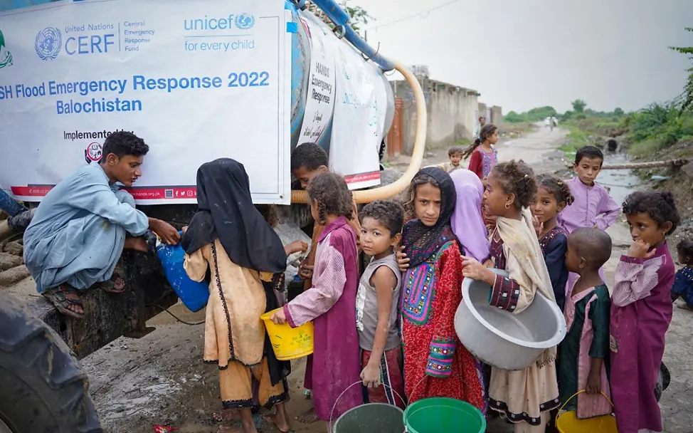 Pakistan: Kinder warten auf Trinkwasser an einem UNICEF-Wassertruck.