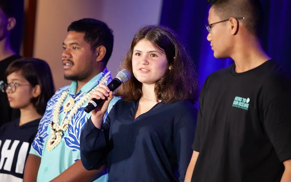 Junge Menschen für mehr Klimaschutz | © UNICEF/Chalasani Kinderrechtsbeschwerde: Raina Ivanova steht neben anderen Jugendlichen und spricht in ein Mikrofon.