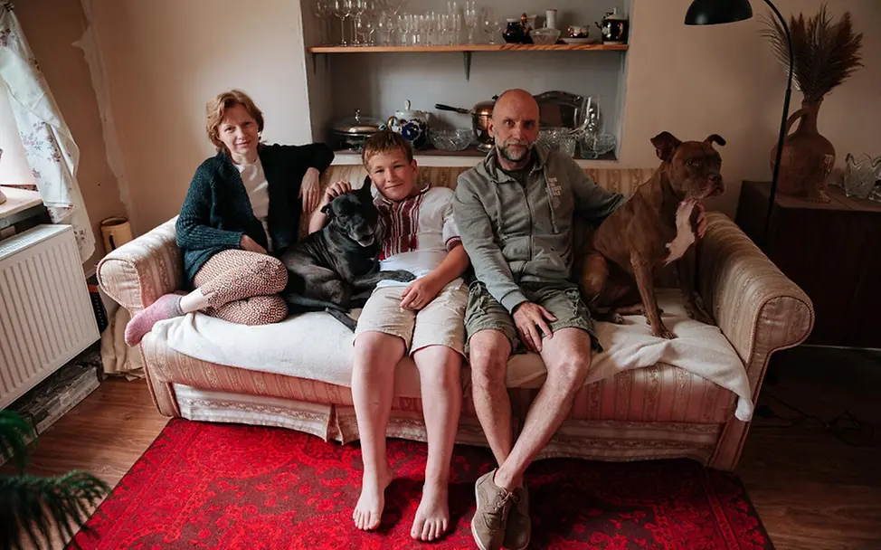 UNICEF | Hilfe für Kinder in der Ukraine | © UNICEF/Pashkina UNICEF | Hilfe für Kinder in der Ukraine: Eine Junge sitzt mit seinen Pflegeeltern auf der Couch.