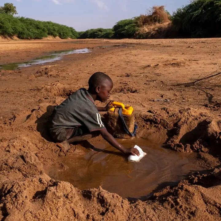 Klimawandel und Kinderrechte | © UNICEF/Rich Somalia: Junge sammelt Wasser in einer Pfütze.