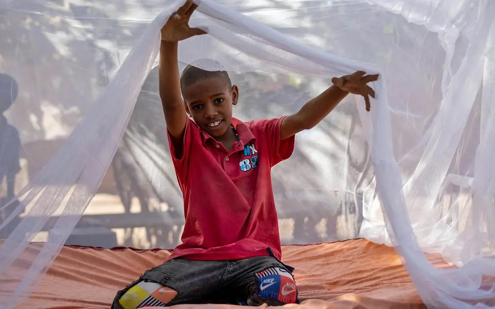 Malaria Kinder schützen: UNICEF hilft Millionen Kindern im Kampf gegen die Malaria-Erkrankung | © UNICEF/Mahmoud Ein Junge im Sudan unter einem Moskitonetz.