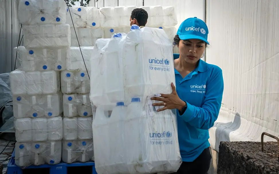 Eine UNICEF-Mitarbeiterin bereitet Trinkwasser-Lieferungen vor. | © UNICEF/Lateef UNICEF-Hilfe für Rohingya: Eine UNICEF-Mitarbeiterin bereitet Trinkwasser-Lieferungen vor.