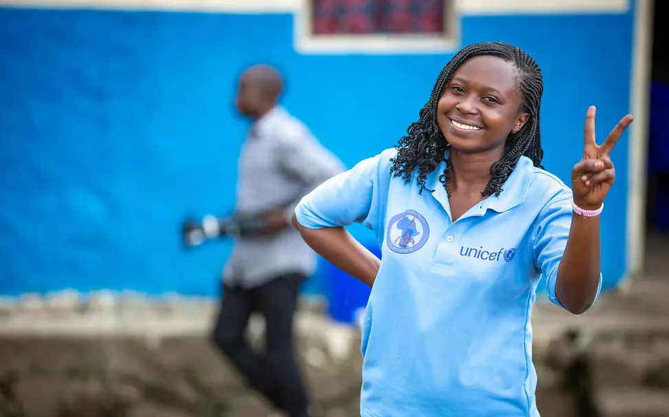 UNICEF-Helferin für ehemalige Kindersoldaten im Kongo zeigt Peace-Zeichen | © UNICEF/ Vigné Kindersoldaten: UNICEF-Helferin im Kongo