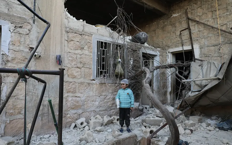 Ein Jahr nach den verheerenden Erdbeben | UNICEF/Ashawi Syrien: Der kleine Musa steht vor dem beschädigten Haus seiner Familie.