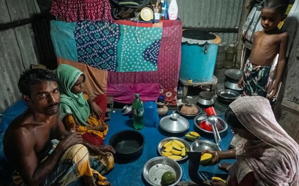 Bangladesch: Leben in einer Notunterkunft. | © UNICEF/Sokhinladesch_Familie_Blog_Wirbelstürme© UNICEF/Sokhin Familie sitzt gemeinsam auf dem Boden in einer Notunterkunft.