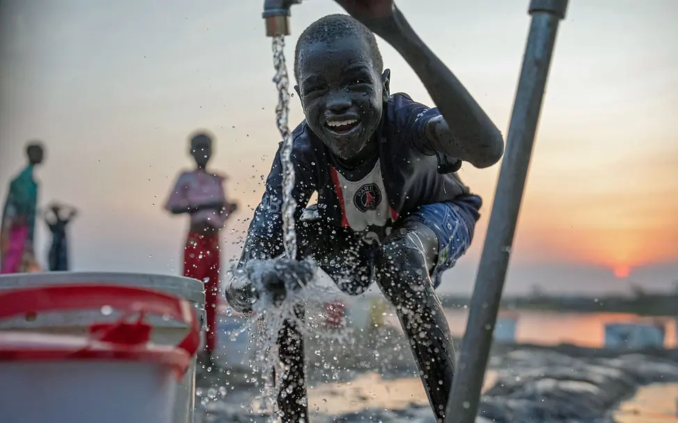 Ein südsudanesischer Junge wäscht sich die Hände | © UNICEF/UNI519261 Südsudan Binnenvertriebene: Ein Junge wäscht sich an einem Wasserhahn die Hände.