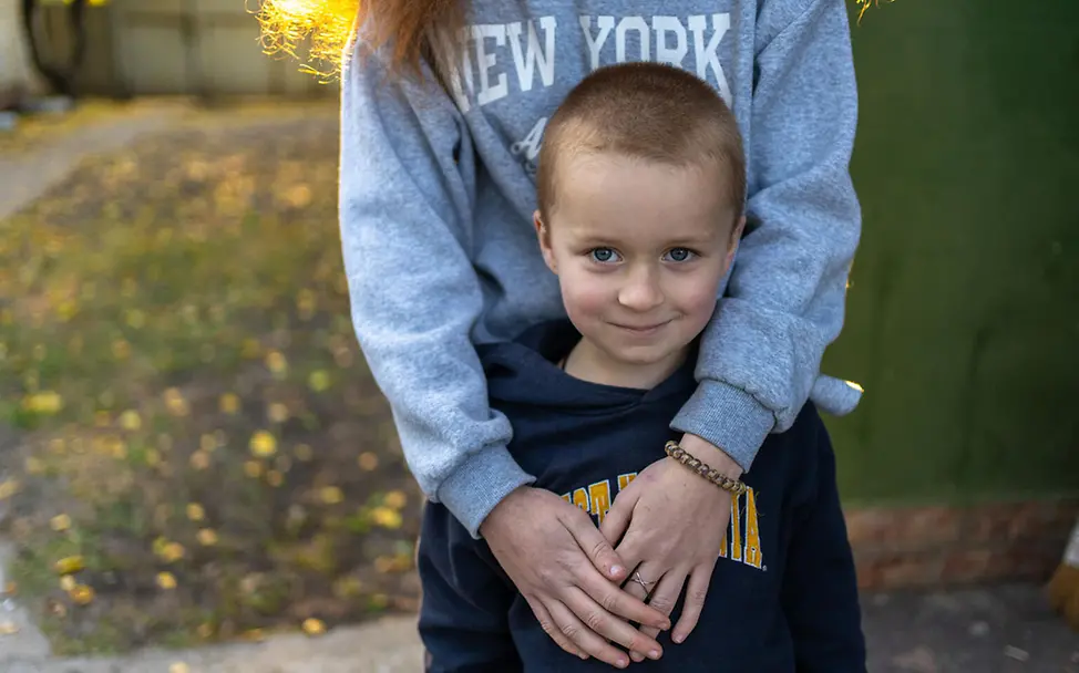 Ukraine Winter humanitäre Hilfe: Ein Junge steht sicher in den Armen seiner Schwester 