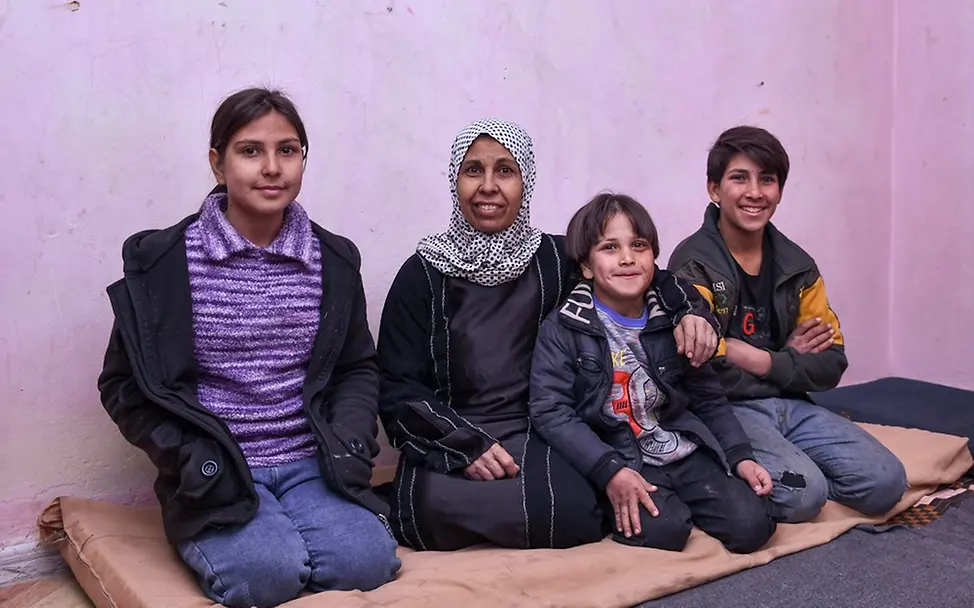 Viele Menschen in Syrien sind von Armut bedroht. | UNICEF/Shahan Farha sitzt mit ihren Kindern in ihrer kleinen Wohnung.