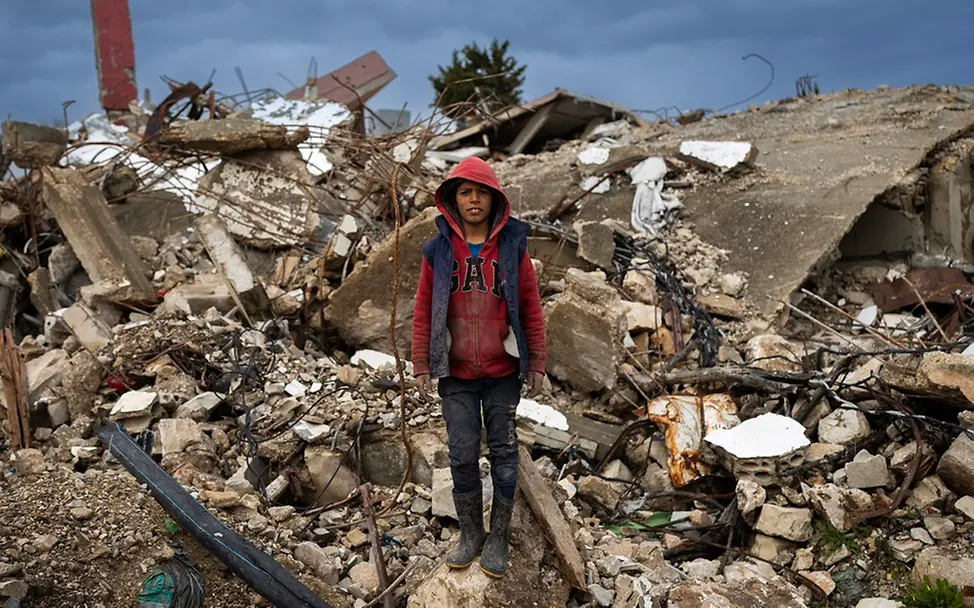 Die Folgen des Krieges im Libanon | UNICEF/UNI753031 Libanon: Shadi (11) steht vor einem zerstörten Haus