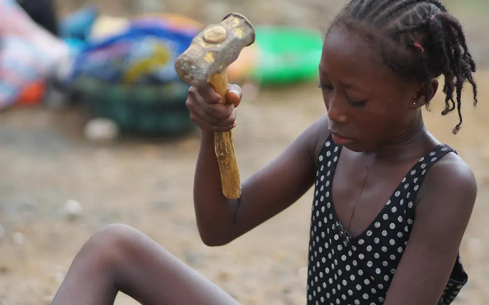 Die 12-jährige Adama bei ihrer Arbeit im Steinbruch. | © UNICEF/Songa Die 12-jährige Adama bei der Arbeit mit einem Hammer in der Hand.