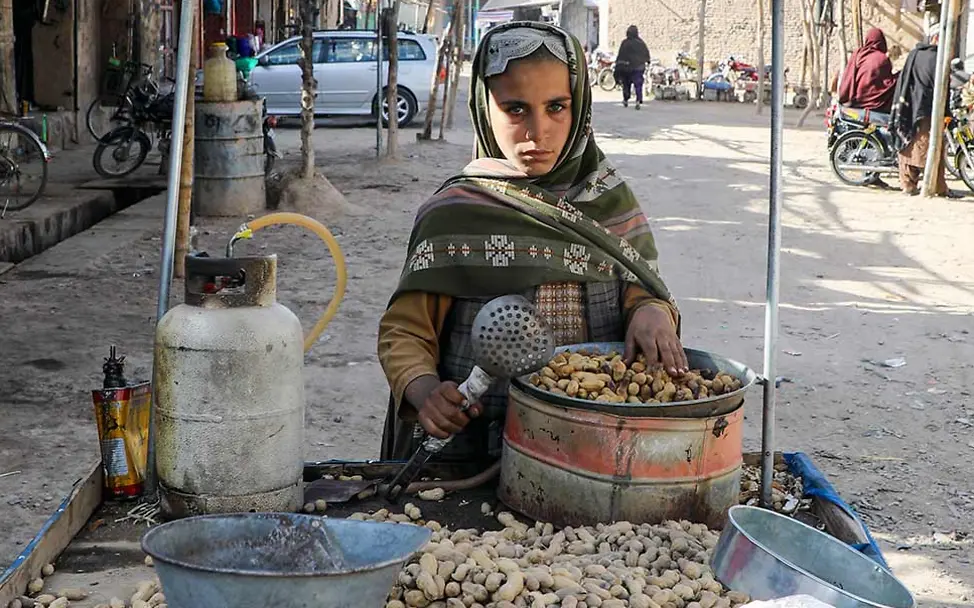Was kann man gegen Kinderarbeit tun: Ein Junge in Asien verkauft geröstete Erdnüsse. 