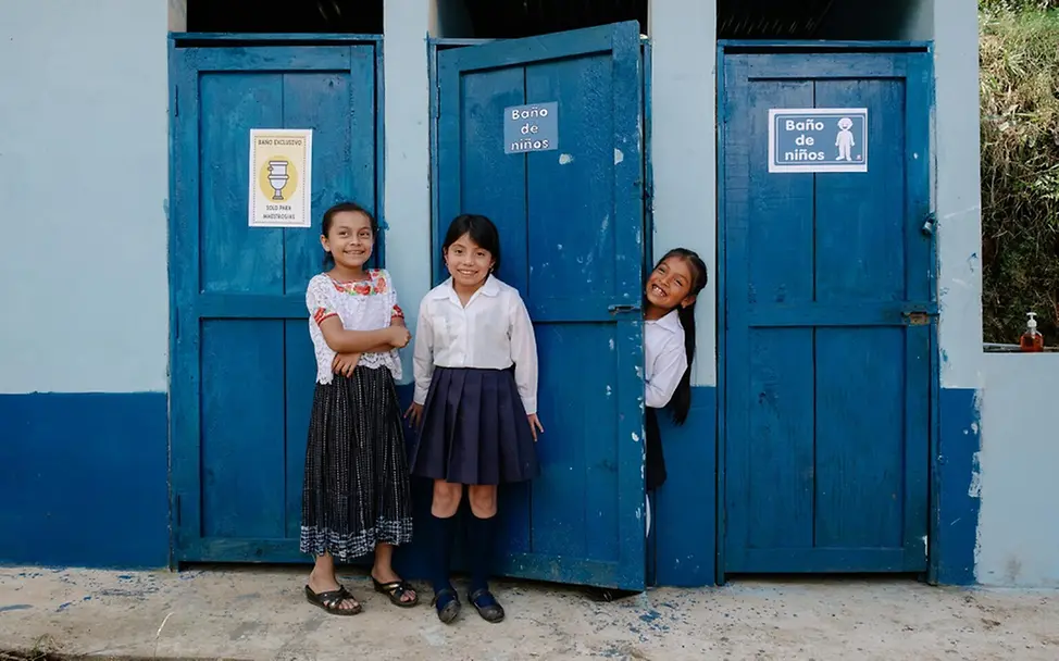 Vilma und ihre Freundinnen freuen sich über ihre neuen Sanitäranlagen an ihrer Schule