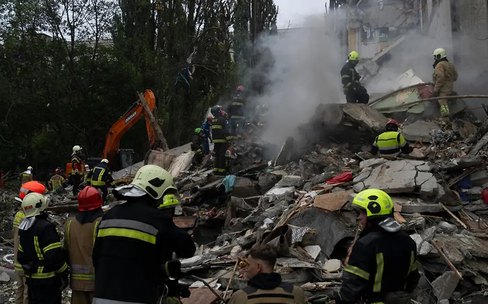 Rettungskräfte durchsuchen Trümmer. | © UNICEF/Filippov Rettungskräfte durchsuchen Trümmer eines Wohngebäudes.