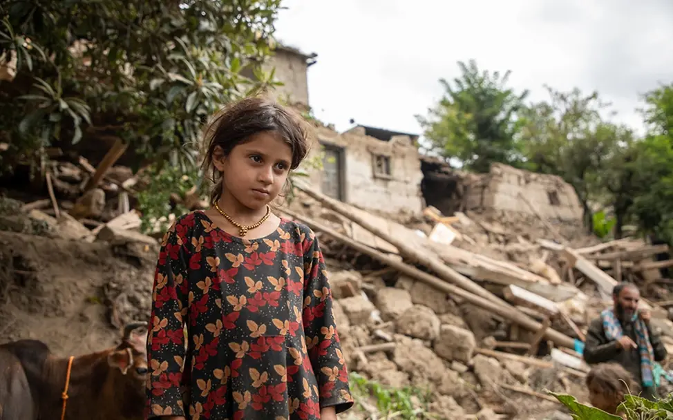 Aziza (6) starrt auf die Ruinen ihres Hauses in Afghanistan. | © UNICEF/Meerzad UNI859079