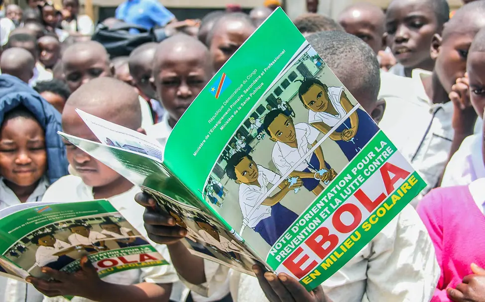 Ebola Kongo: Schülerinnen und Schüler lesen in einer Ebola-Aufklärungsbroschüre