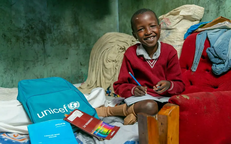 Kenia: In einem Slum in Nairobi zeigt Octavia stolz ihre Schulsachen | © UNICEF/TransLieu/Nyaberi Die zehnjährige Octavia zeigt die Schulsachen, die sie als Teil von Hilfsgütern von UNICEF erhalten hat.