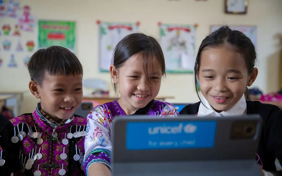 Vietnam: Drei Kinder lernen das erste Mal mit einem Tablet. I © UNICEF/UNI765626/Vu Le Hoang Mit einem Tablet lernen? Das ist für diese Kinder hier eine neue Erfahrung. Hilfsgüter von UNICEF sind innovativ!