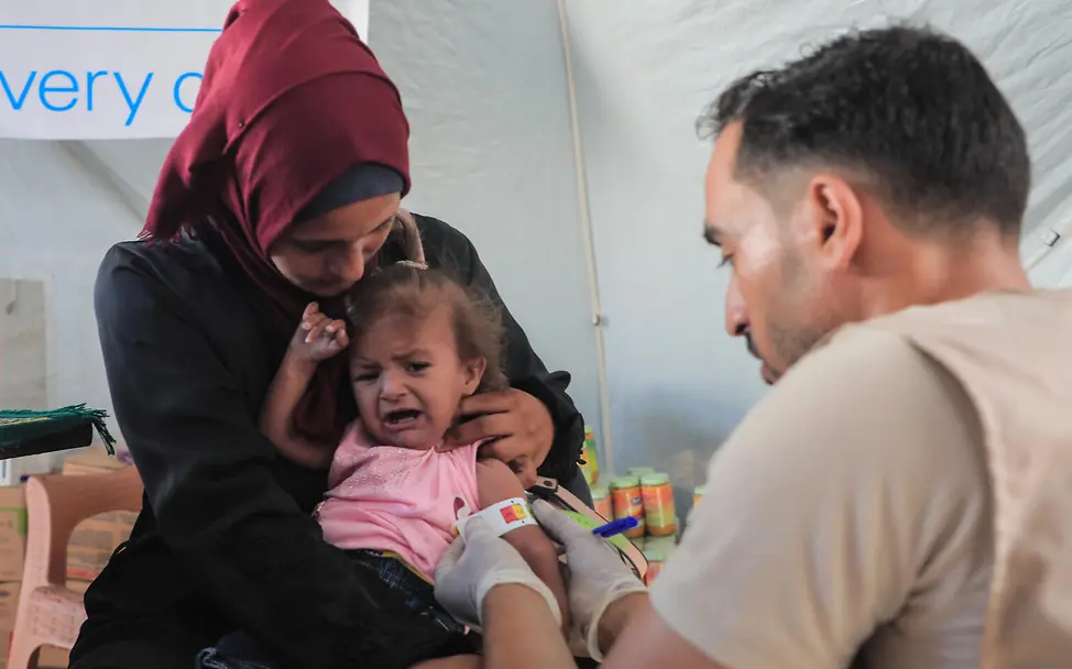 Gaza: Die 2-jährige Masa ist stark unterernährt. I © UNICEF/UNI856405/Nateel Ein unterernährtes Kind in Gaza wird von einem Gesundheitsmitarbeiter gemessen. Die Menschen benötigen dringend Hilfsgüter.