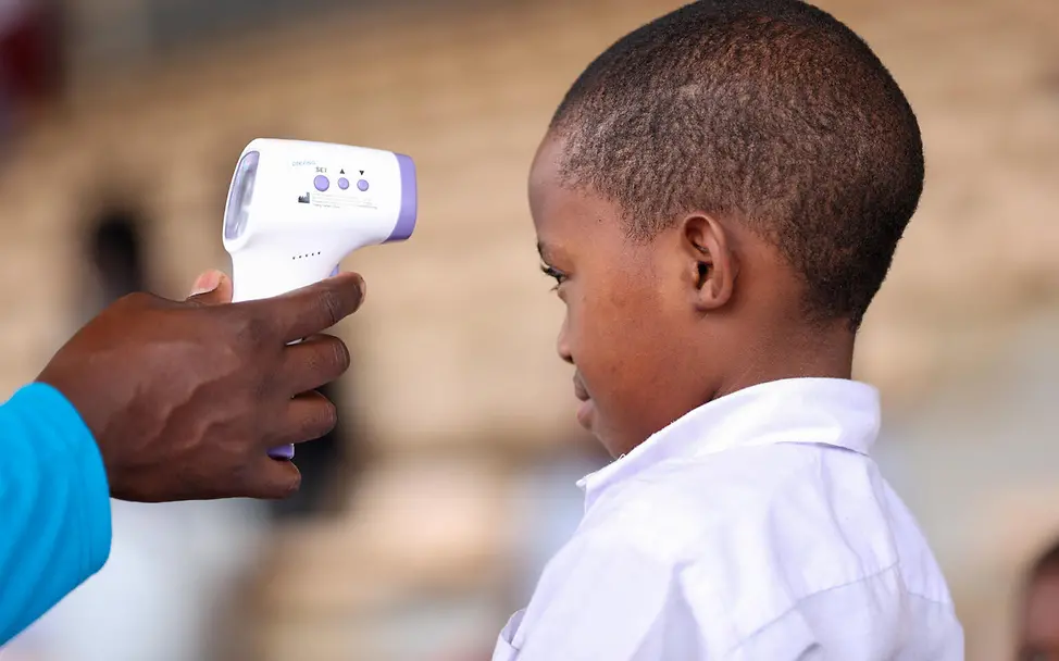 Ebola Früherkennung: Bei einem Schüler in Uganda wird mit einem Fieberthermometer die Temperatur gemessen. 