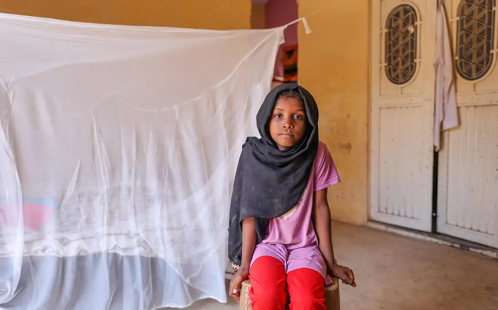 Ein Mädchen sitzt vor einem Bett, das mit einem neuen Moskitonetz geschützt ist | © UNICEF/Isamaldeen Sudan Krieg: Ein Mädchen sitzt vor einem mit einem Moskitonetz geschützten Bett.