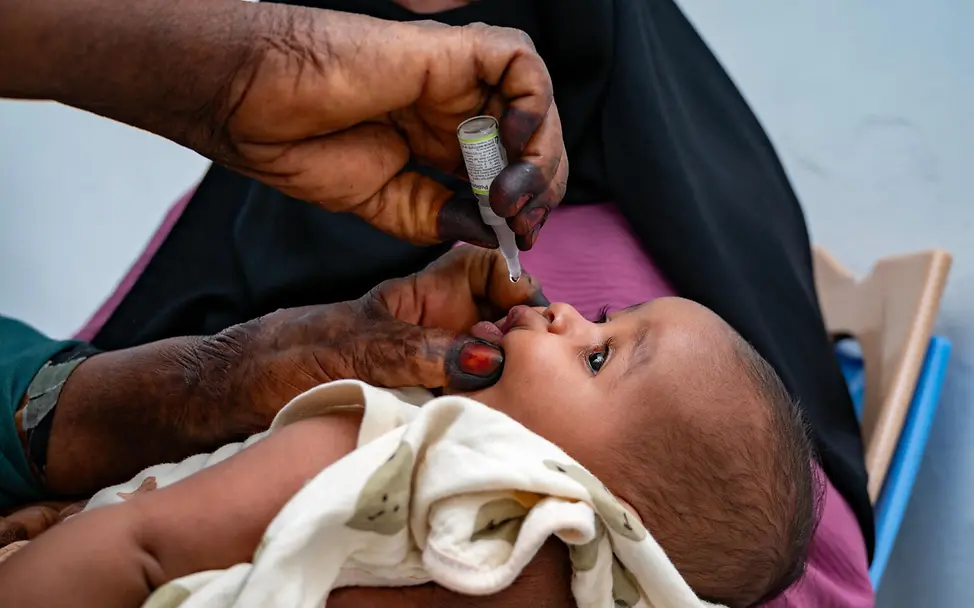 Ein Baby im Sudan wird gegen Infektionskrankheiten geimpft | © UNICEF/Abdulmajid Sudan Krieg: Ein Baby im Bundesstaat Kassala bekommt eine Schluckimpfung als Schutz vor Krankheiten.