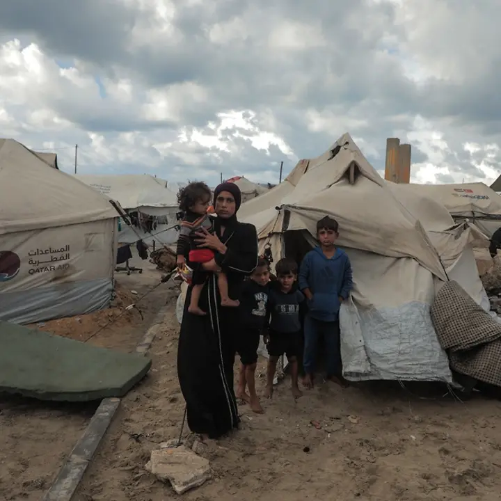 Maysaa lebt mit ihren Kindern in einem Zelt | UNICEF/Nateel Maysaa steht mit ihren Kindern vor einem provisorischen Zelt