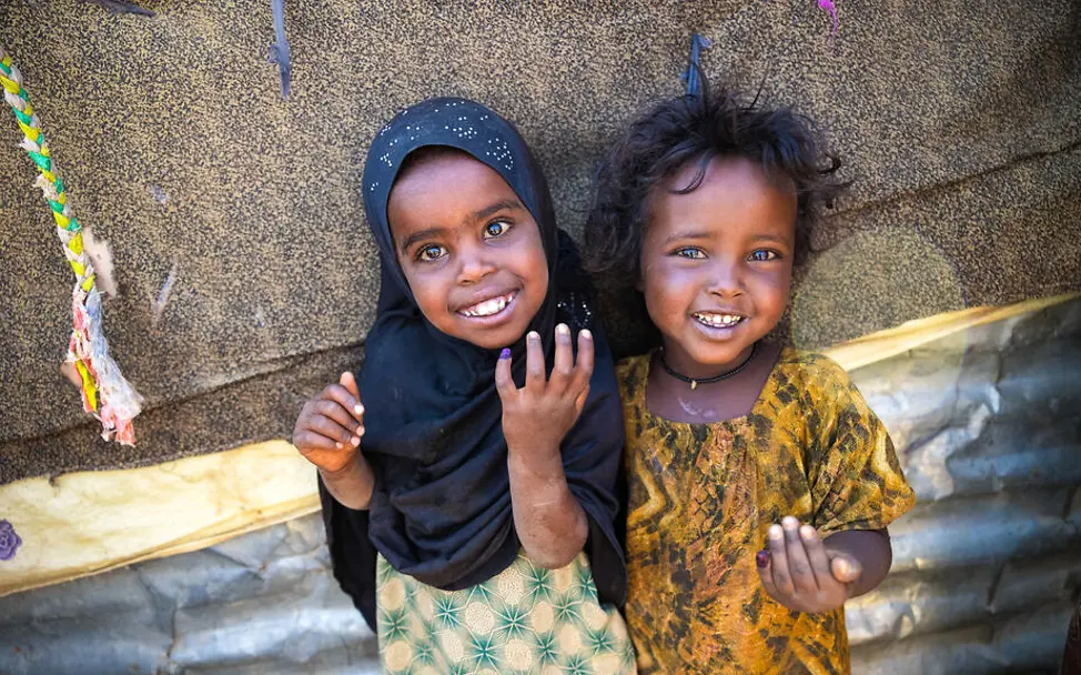 Äthiopien: Zwei Mädchen lächeln und zeigen ihre nach der Impfung violett markierten Finger.