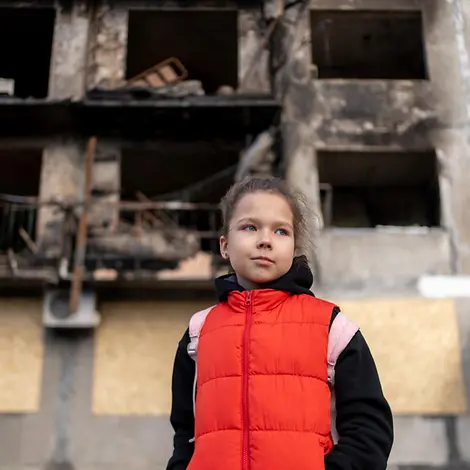 Mit Kindern über Krieg sprechen: Ein Mädchen vor den Trümmern eines Hauses im ukrainischen Kiew. 