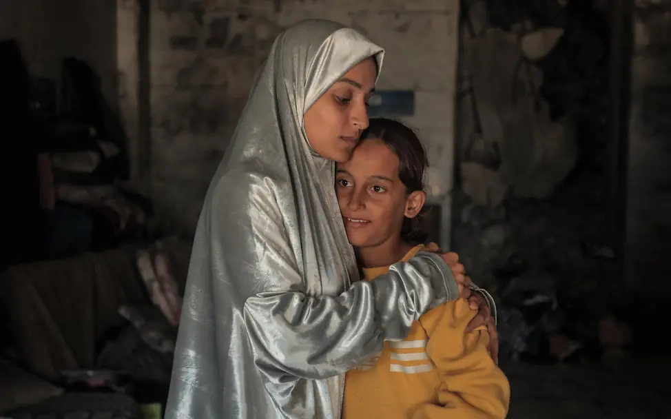 Mit Kindern über Krieg sprechen: Eine Mutter umarmt ihre Tochter in einer zerstörten Moschoee in Gaza. 