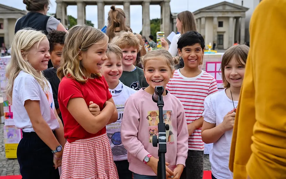 Was ist Demokratie einfach erklärt: Kinder in Berlin vor dem Brandenburger Tor