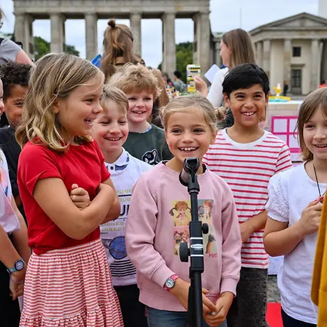 Was ist Demokratie einfach erklärt: Kinder in Berlin vor dem Brandenburger Tor