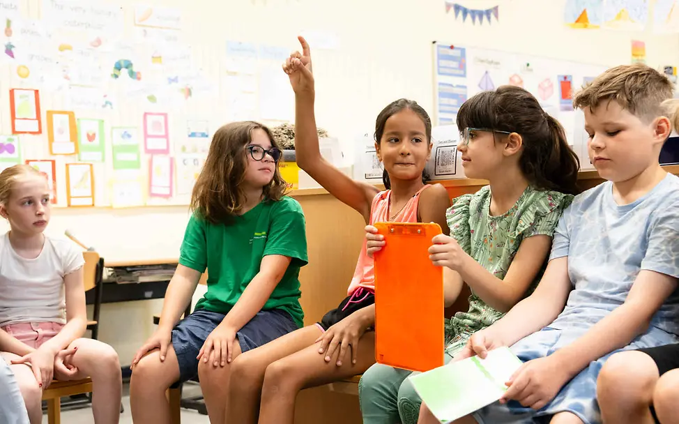 Menschenrechte einfach erklärt: Kinder sitzen in einem Klassenraum und sprechen.